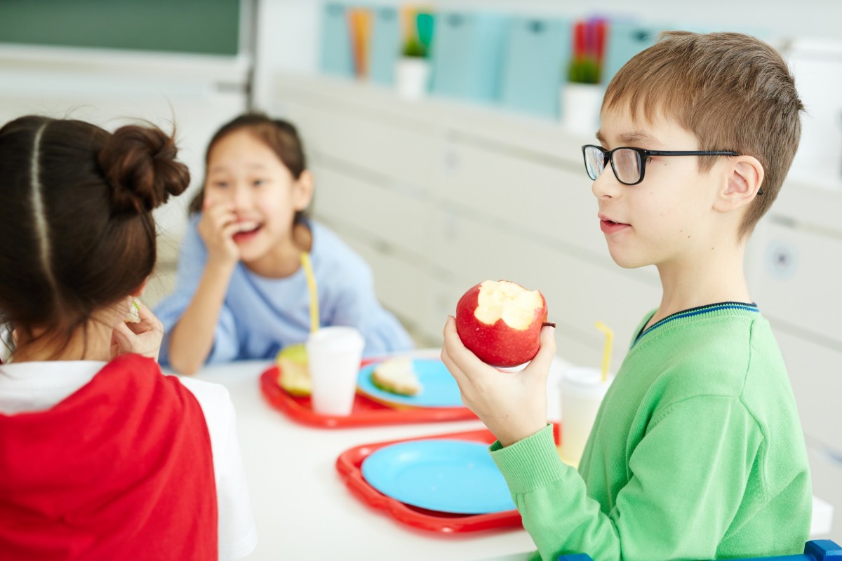 Trois enfants qui mangent une collation.